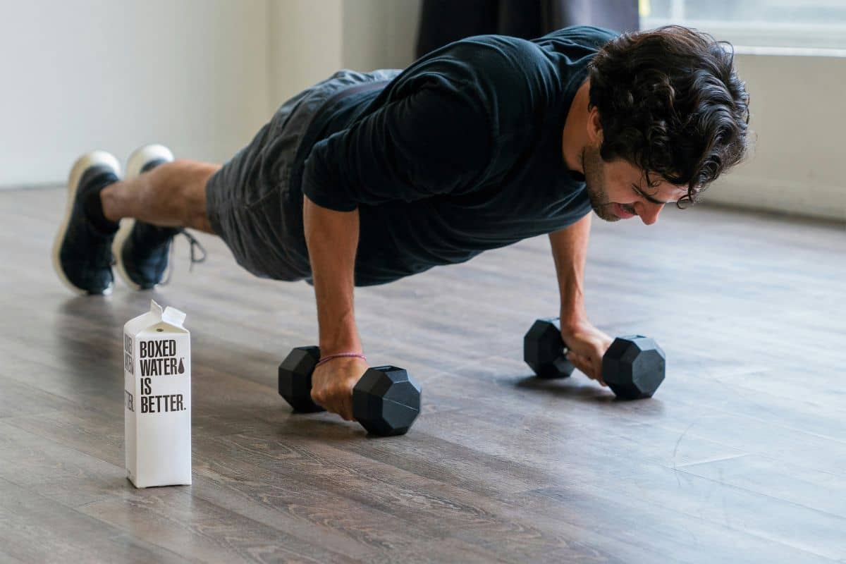 A man performing push-ups on a wooden floor